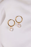 Gold hoop earrings with pearl drops on a white background