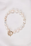 White Pearl bracelet with a gold clasp on a white background