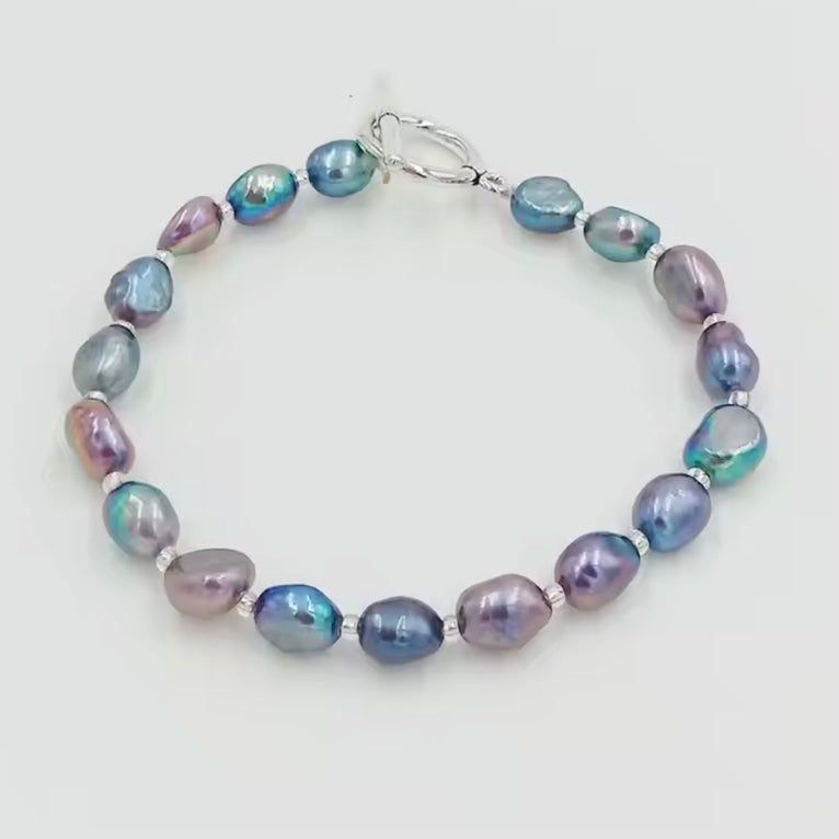 Black Pearl bracelet with blue and purple beads on a light gray background