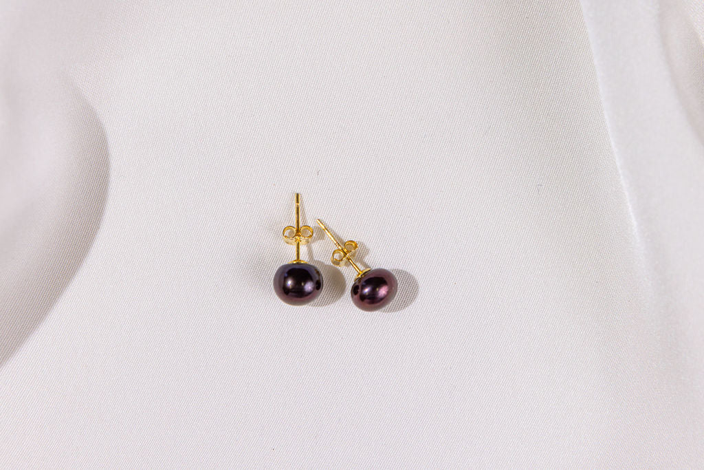 Pair of pearl earrings with gold posts on a white background