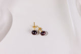 Pair of pearl earrings with gold posts on a white background