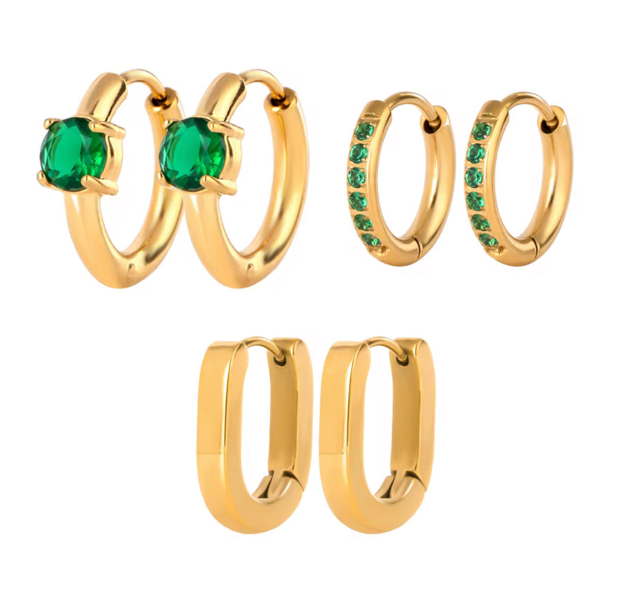 Set of gold hoop earrings with green gemstones on a white background