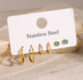 Set of gold and turquoise earrings on a 'Stainless Steel' card with a beige background