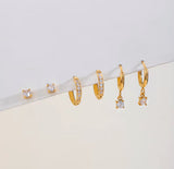 Set of gold earrings on a light gray background