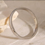 Silver ring on a textured beige surface