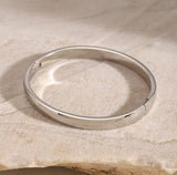 Silver bracelet on a textured beige surface
