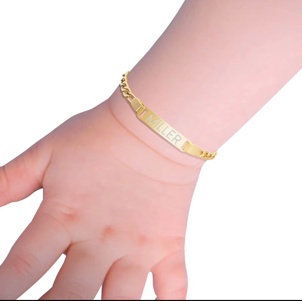 Gold bracelet with engraved name on a wrist against a white background