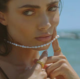 lady in swmmers with gold waterproof ring and pearl necklace