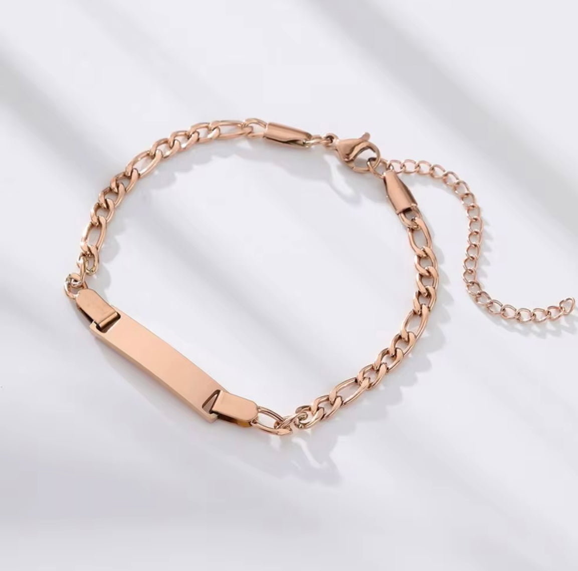 Rose gold chain bracelet on a light background