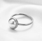 Silver ring with a pearl on a white fabric background