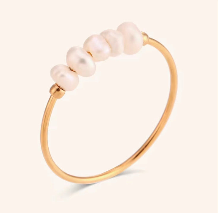 Pearl gold ring with pearls on a light beige background