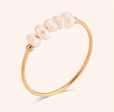 Pearl gold ring with pearls on a light beige background