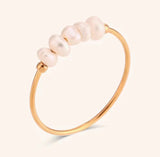 Pearl gold ring with pearls on a light beige background