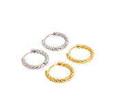 Four gold and silver hoop earrings on a white background