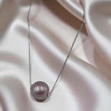 Perfect round purple earl necklace on a soft fabric background