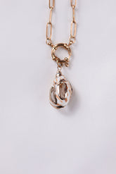 Necklace with a shell pendant on a light gray background