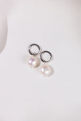 Pearl earrings with silver rings on a white background