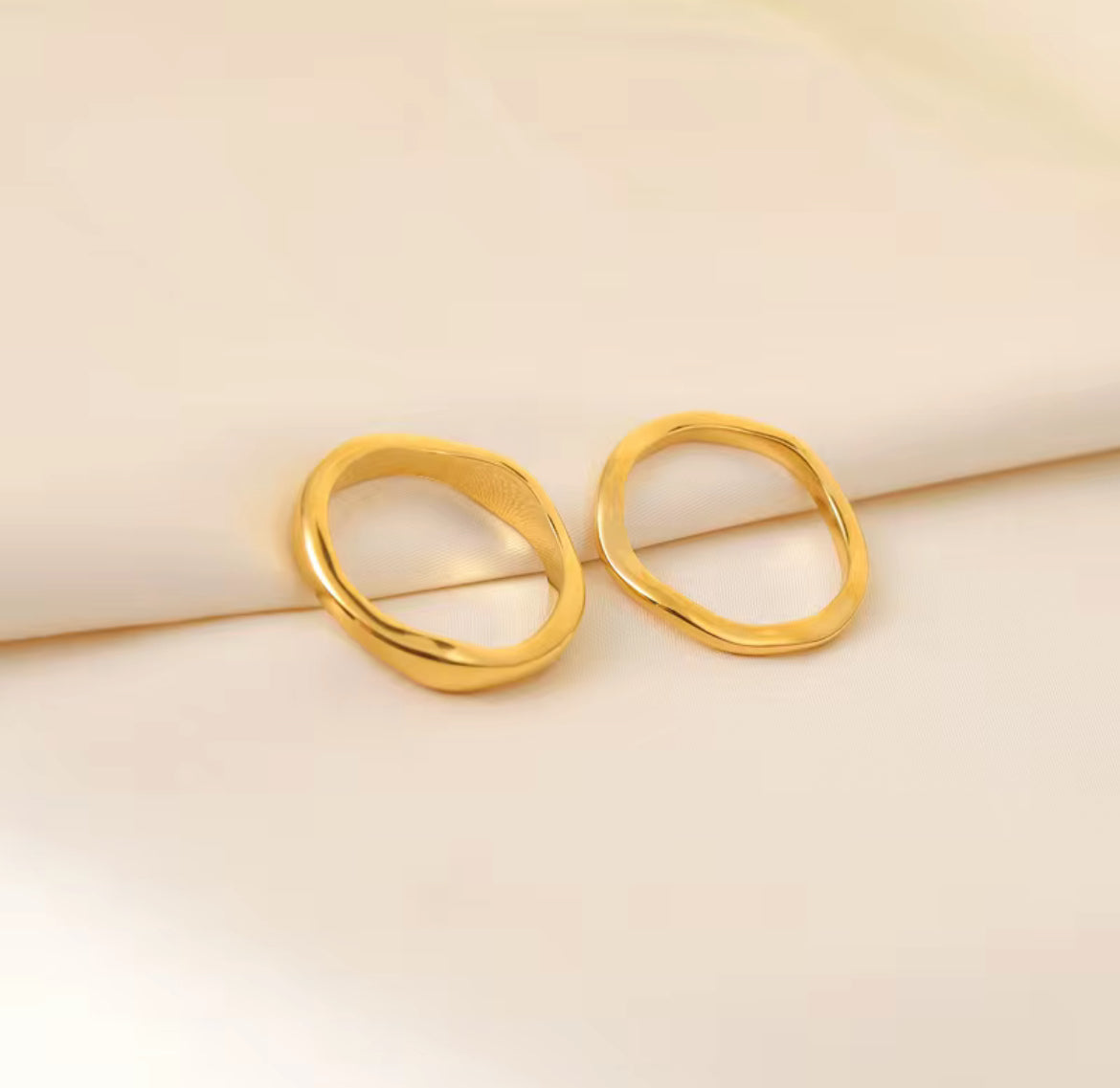 Pair of gold earrings on a beige background