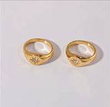 Two gold rings with diamond accents on a light gray background