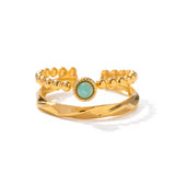 Gold ring with a green gemstone on a white background