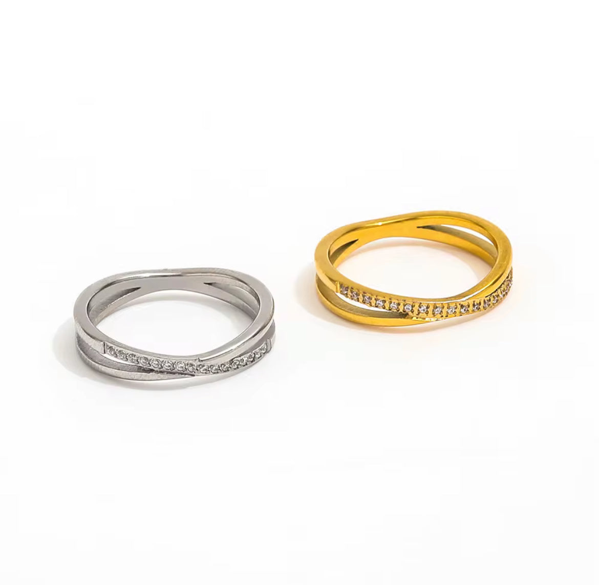 Two rings, one silver and one gold, on a white background