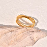 Gold ring with embedded stones on a textured stone surface