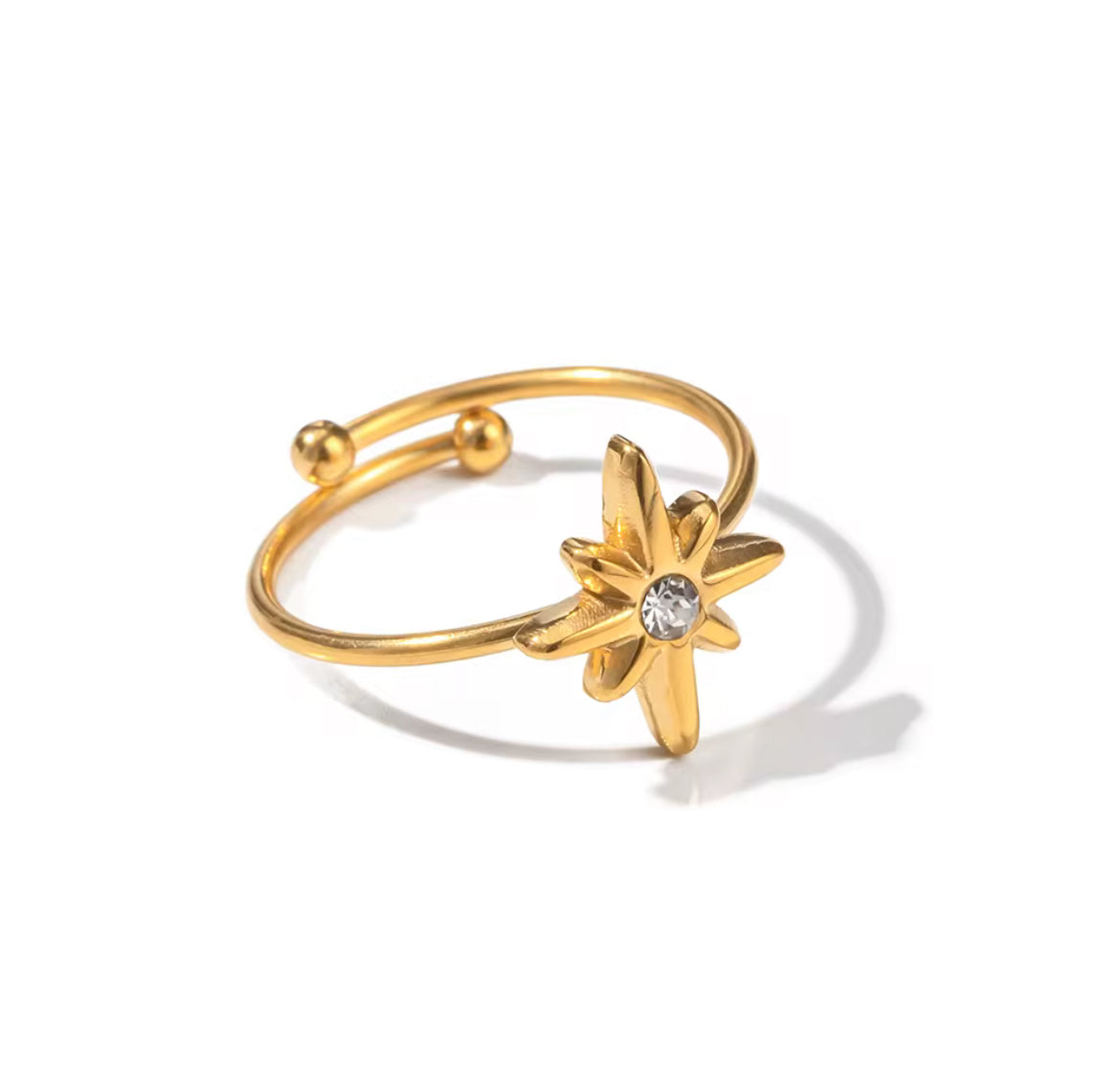Gold ring with star-shaped design on a white background