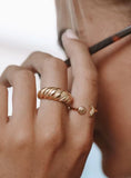 Gold ring on a person's finger with a blurred background