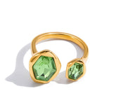 Gold ring with green gemstones on a white background