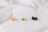 Three pairs of pearl earrings on a white fabric background