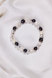 Pearl bracelet with black beads on a white surface