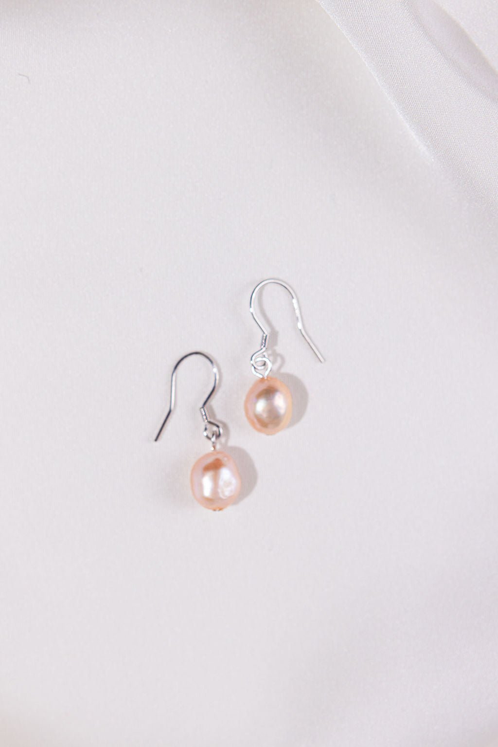 Pair of pearl earrings on a light gray background