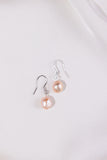 Pair of pearl earrings on a light gray background