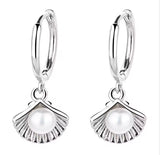 Silver earrings with pearl-like charms on a white background