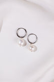 Pearl earrings with silver loops on a white background