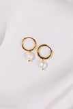 Gold hoop earrings with pearls on a white background