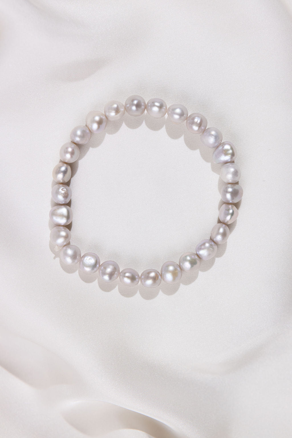 White Pearl bracelet on a white fabric background