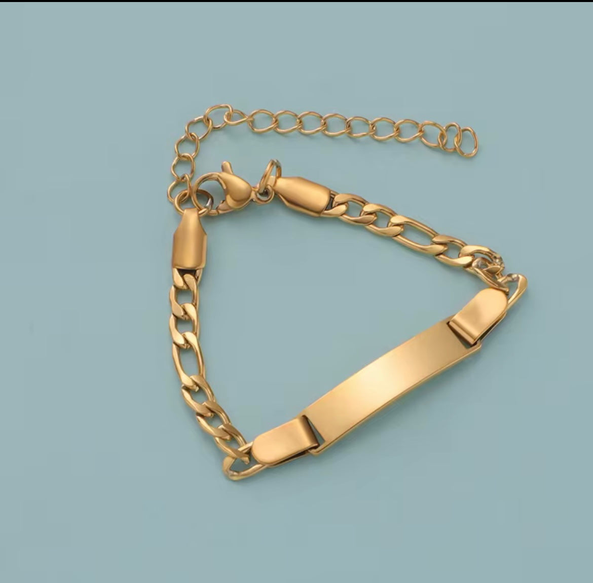 Gold chain bracelet on a light blue background