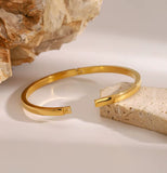 Gold bracelet on a stone surface with a neutral background