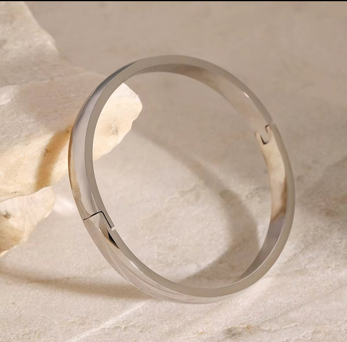 Silver ring on a textured beige surface