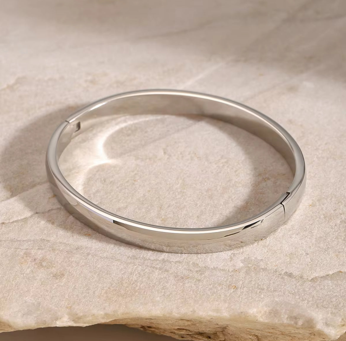 Silver bracelet on a textured beige surface