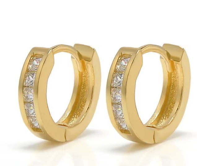 Gold hoop earrings with embedded diamonds on a white background