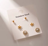 Set of gold earrings on a white card with 'Stainless Steel' text.