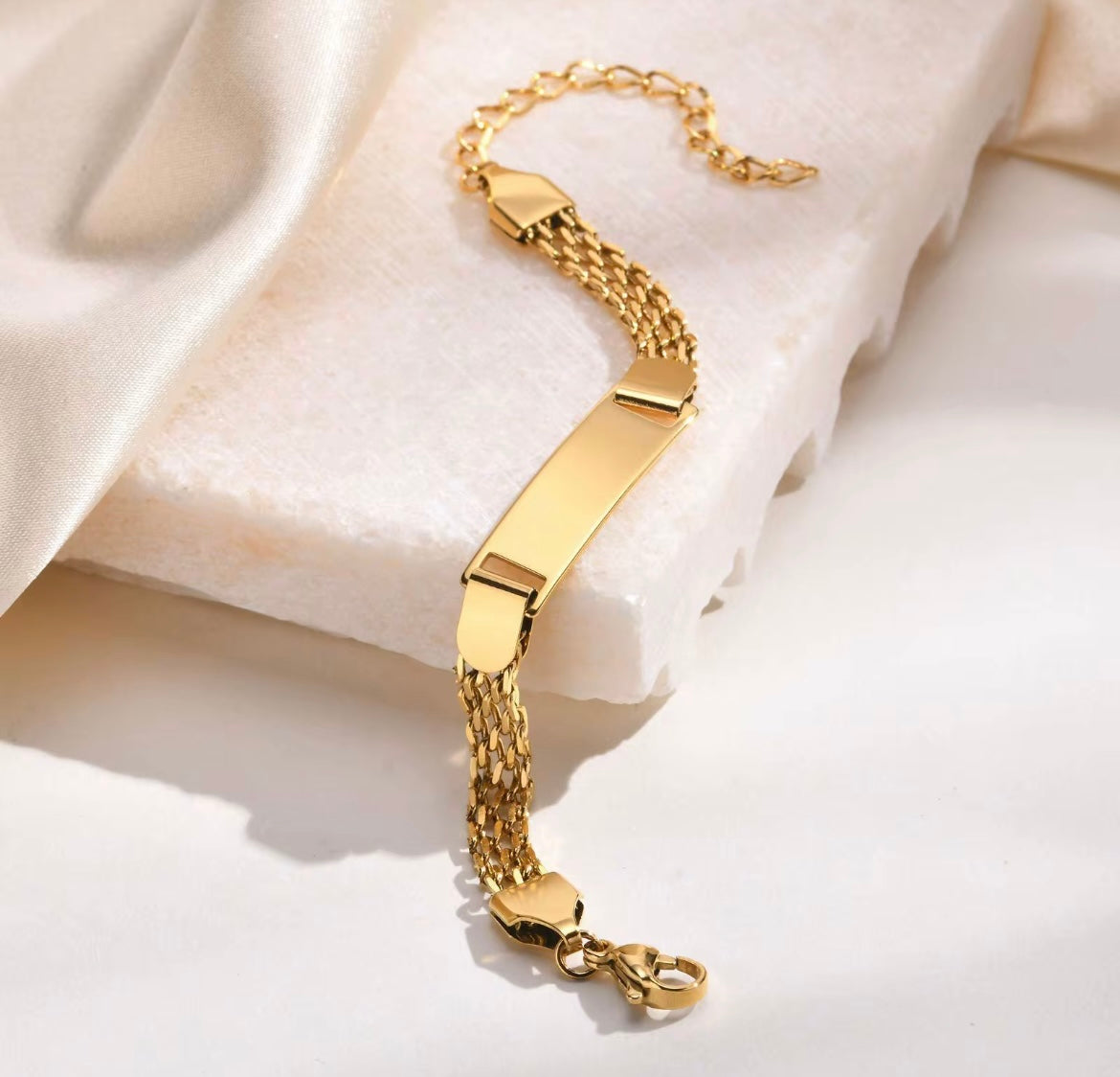 Gold bracelet on a soft beige fabric background
