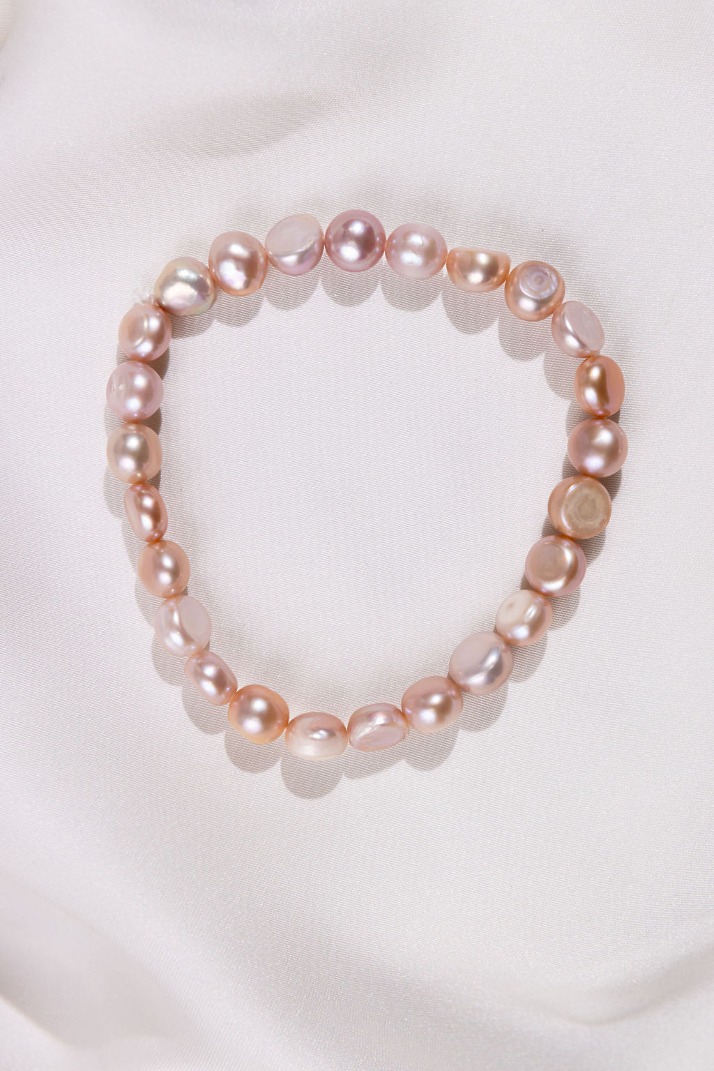 Mixed Pearl bracelet with rose gold accents on a white fabric background