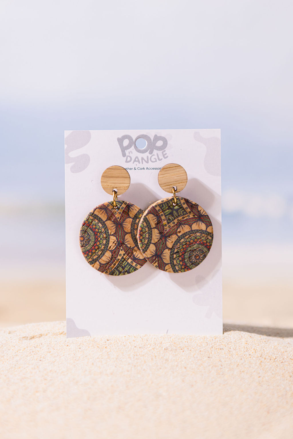 Wooden earrings on a Pop Dangle branded card with a beach background