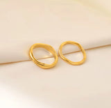 Pair of gold earrings on a beige background