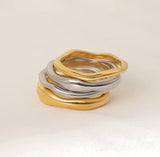 Stack of gold and silver rings on a beige background