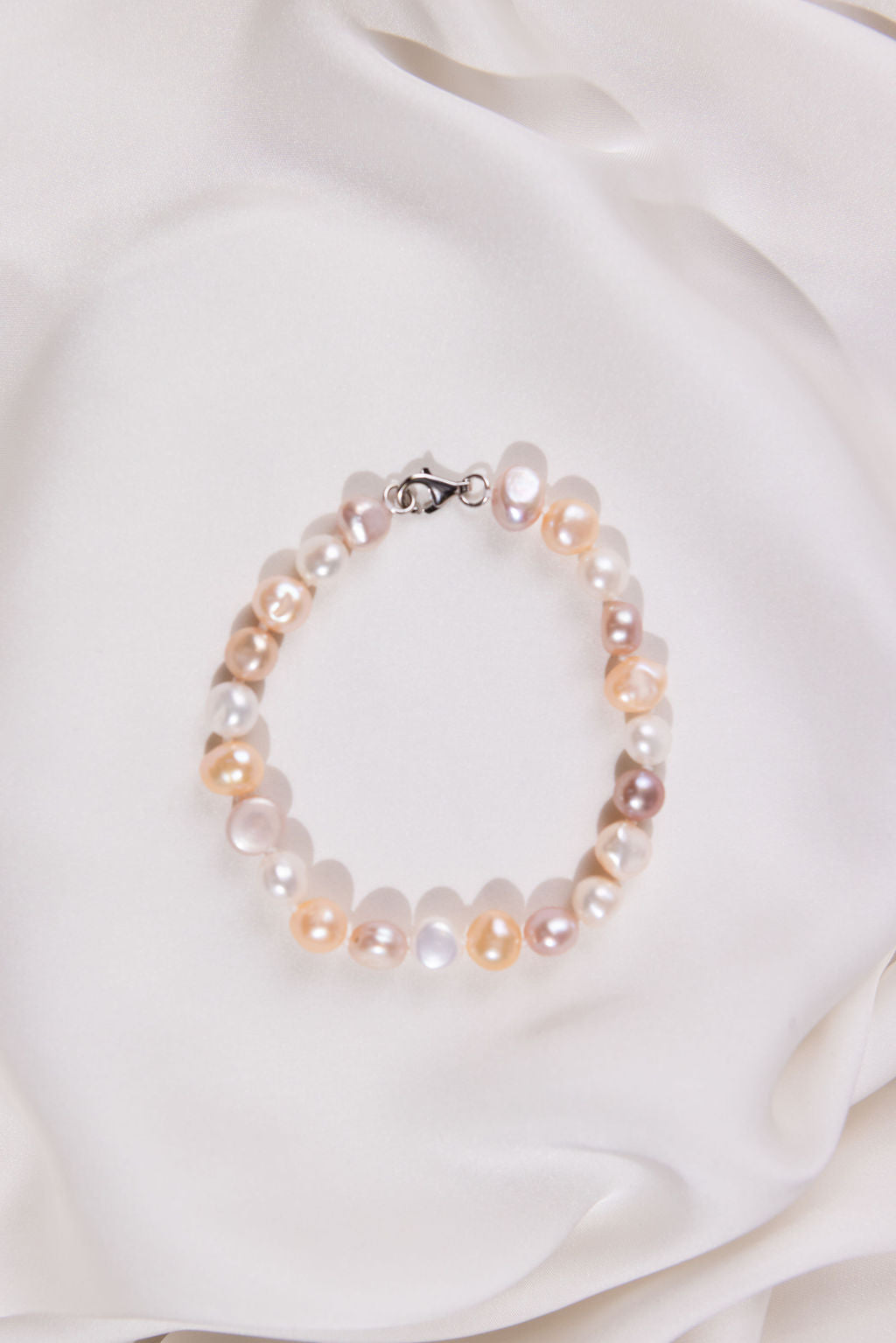 Mixed colour Pearl bracelet on a white fabric background