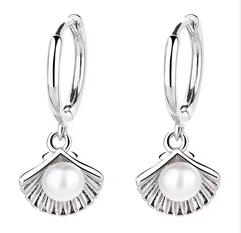 Silver earrings with pearl-like charms on a white background
